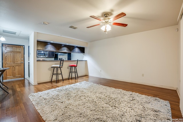 interior space featuring dark wood-type flooring and ceiling fan