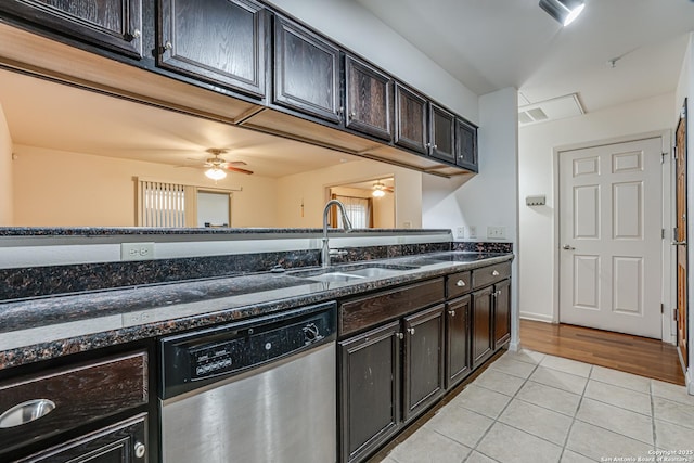 kitchen with sink, dark stone countertops, stainless steel dishwasher, light tile patterned floors, and dark brown cabinets