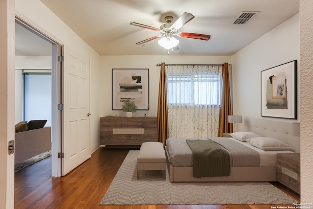 bedroom with dark hardwood / wood-style flooring and ceiling fan