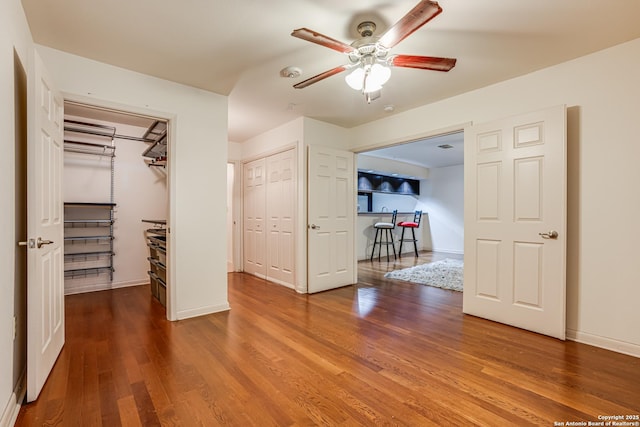 unfurnished bedroom featuring hardwood / wood-style flooring and two closets