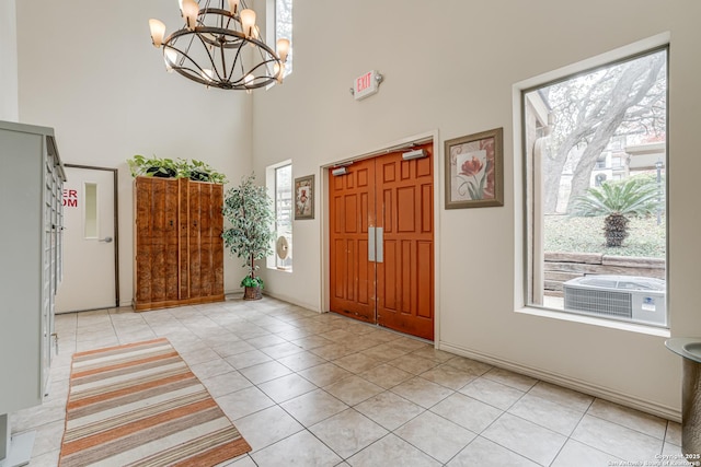 tiled foyer entrance with a towering ceiling and a notable chandelier