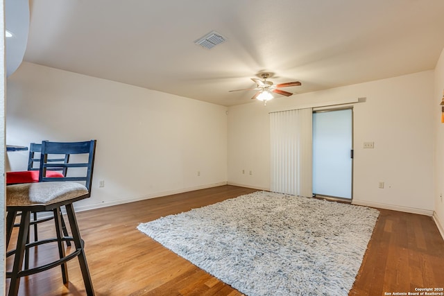 interior space with wood-type flooring and ceiling fan