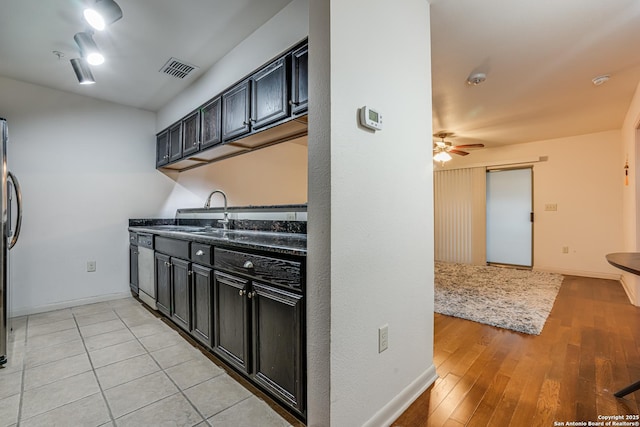 kitchen with ceiling fan, stainless steel fridge, sink, and light hardwood / wood-style flooring