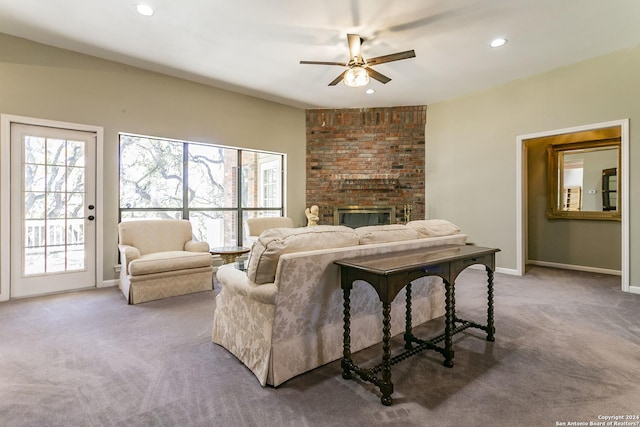 carpeted living room featuring a fireplace and ceiling fan