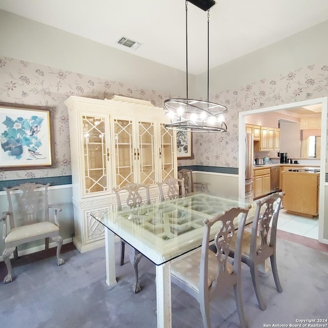 dining space featuring an inviting chandelier and light carpet