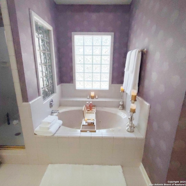 bathroom with a relaxing tiled tub