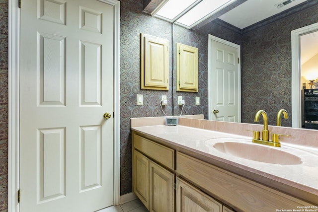 bathroom featuring vanity, a skylight, and tile patterned floors