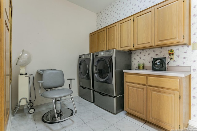 laundry room with light tile patterned flooring, cabinets, and washing machine and clothes dryer