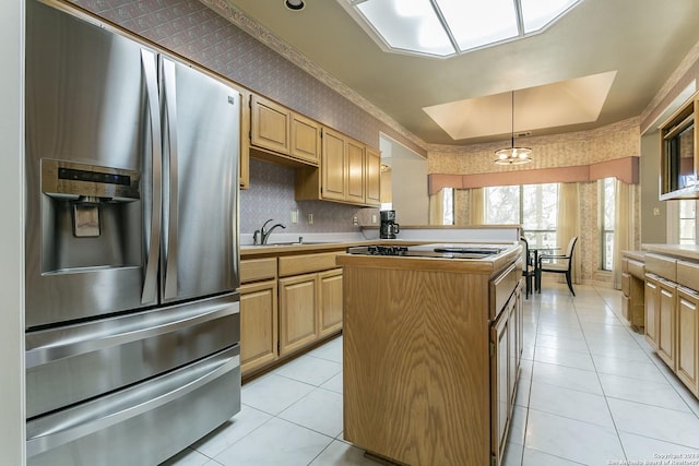 kitchen with light brown cabinetry, sink, stainless steel fridge with ice dispenser, a kitchen island, and pendant lighting