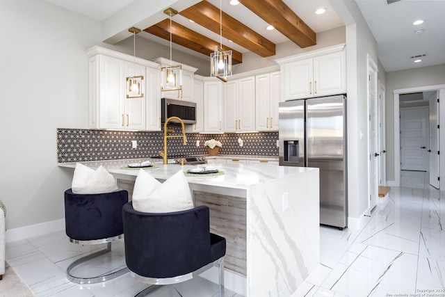 kitchen with white cabinetry, a kitchen bar, hanging light fixtures, and appliances with stainless steel finishes