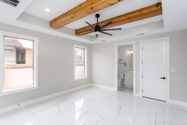 unfurnished bedroom featuring beamed ceiling, a raised ceiling, and connected bathroom