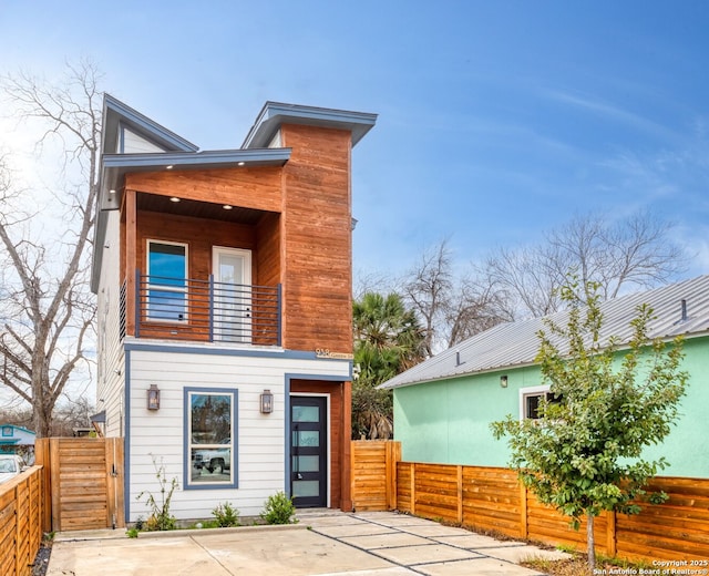 rear view of house with a balcony and a patio