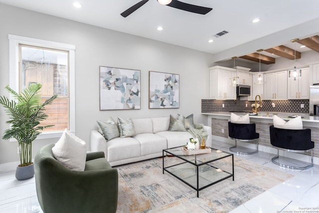 living room with sink, beam ceiling, and ceiling fan