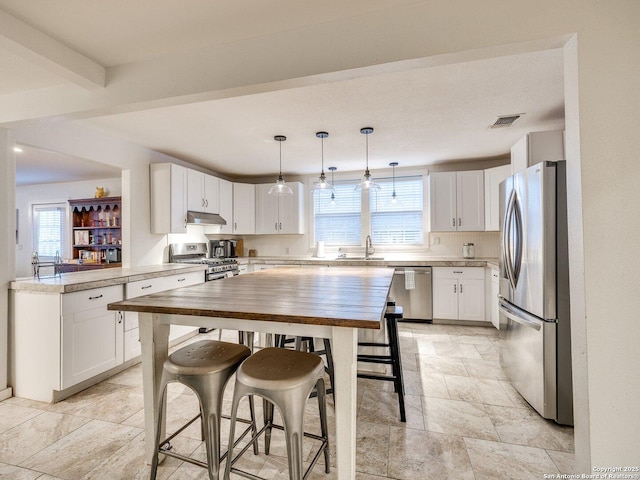 337 W Hackberry St, Fredericksburg, TX 78624 - kitchen featuring sink, decorative light fixtures, kitchen peninsula, stainless steel appliances, and white cabinets