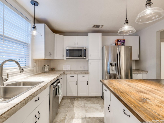 337 W Hackberry St, Fredericksburg, TX 78624 - kitchen with appliances with stainless steel finishes, sink, white cabinets, and decorative light fixtures