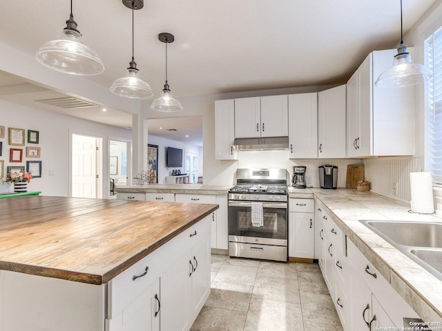 337 W Hackberry St, Fredericksburg, TX 78624 - kitchen with white cabinetry, stainless steel gas range oven, hanging light fixtures, and a kitchen island
