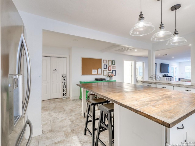 337 W Hackberry St, Fredericksburg, TX 78624 - kitchen featuring white cabinetry, butcher block countertops, hanging light fixtures, and stainless steel refrigerator with ice dispenser