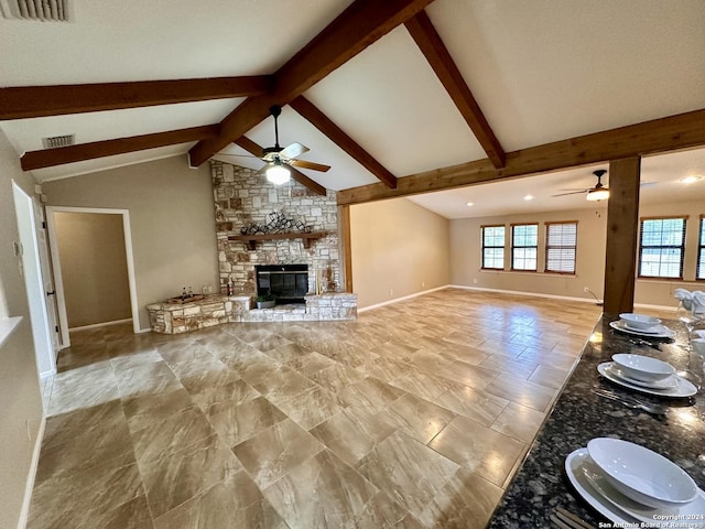 unfurnished living room featuring ceiling fan, vaulted ceiling with beams, and a fireplace