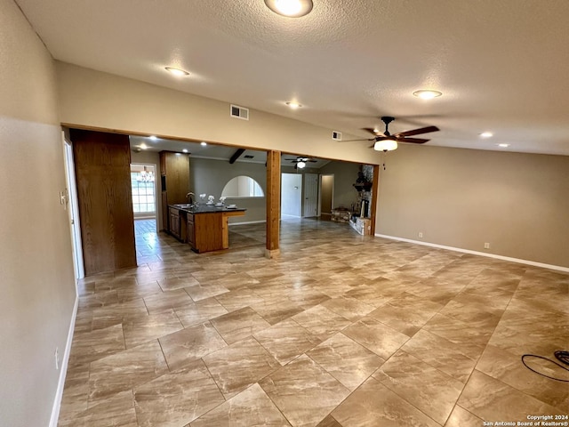 kitchen featuring sink, a textured ceiling, a breakfast bar, and ceiling fan