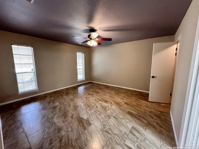 spare room with a textured ceiling and ceiling fan