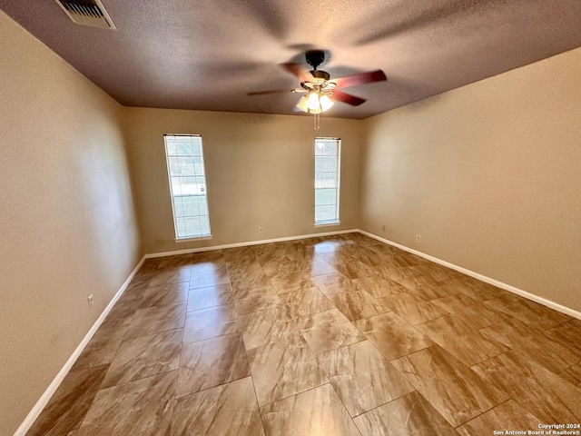 unfurnished room featuring ceiling fan and a textured ceiling