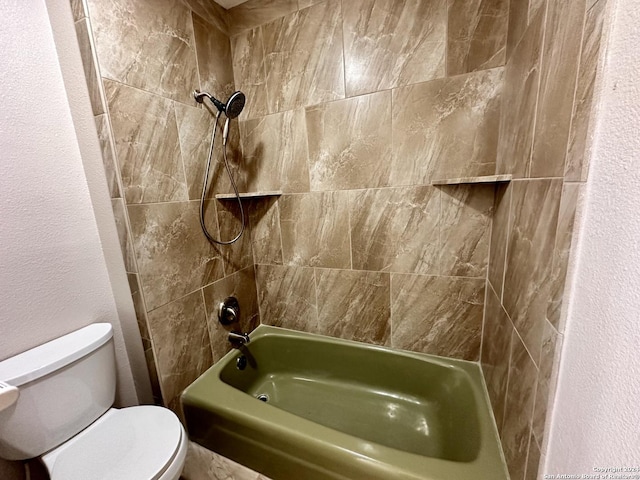 bathroom featuring tiled shower / bath and toilet