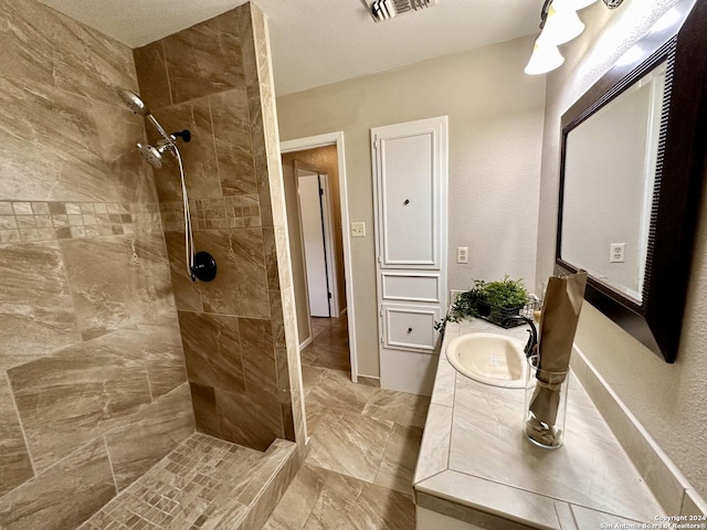 bathroom with vanity and a tile shower