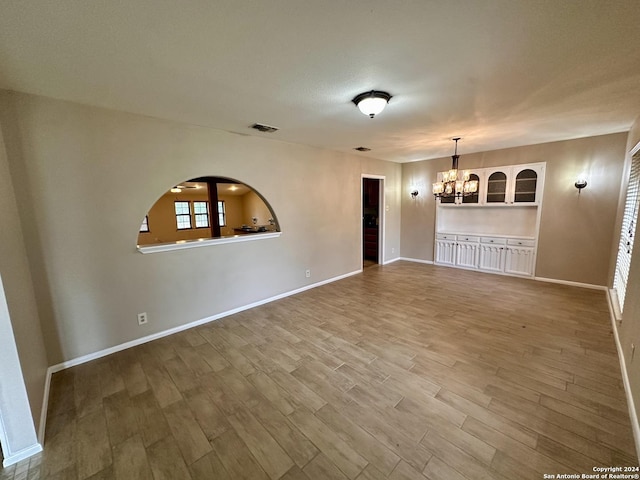 unfurnished room featuring hardwood / wood-style flooring and a notable chandelier