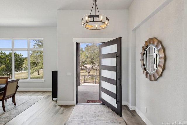 entrance foyer with an inviting chandelier and light wood-type flooring