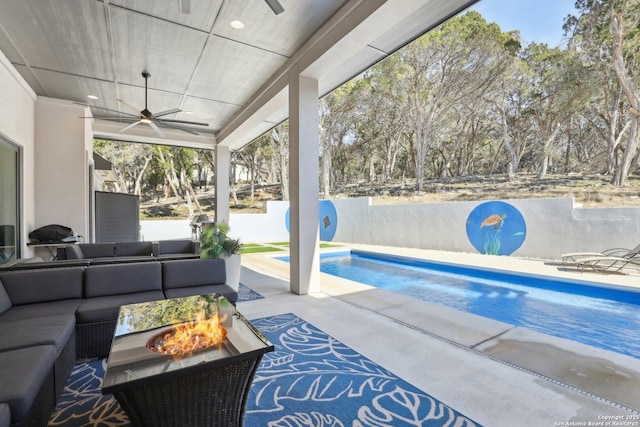 view of pool with ceiling fan, a patio, and an outdoor living space with a fire pit