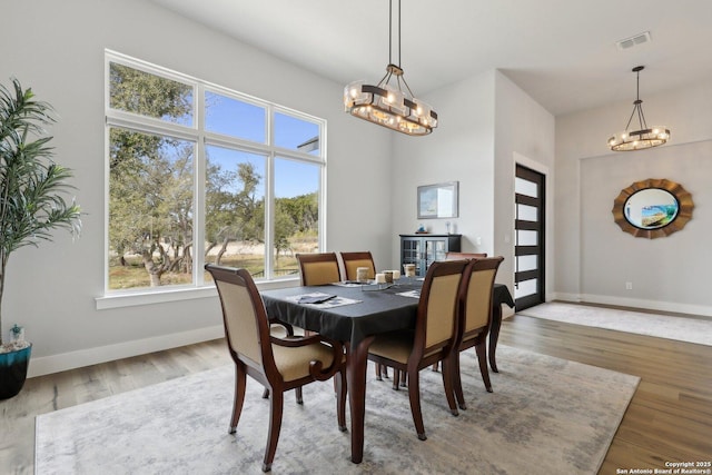 dining space with hardwood / wood-style floors and a chandelier