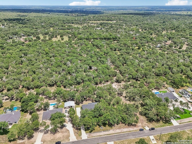 birds eye view of property featuring a view of trees