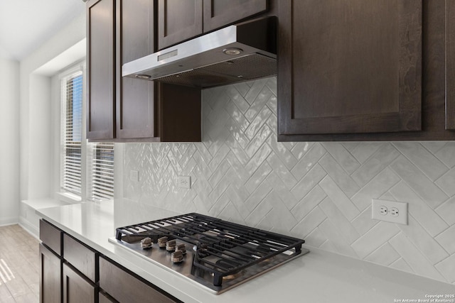 kitchen with tasteful backsplash, stainless steel gas cooktop, and dark brown cabinetry