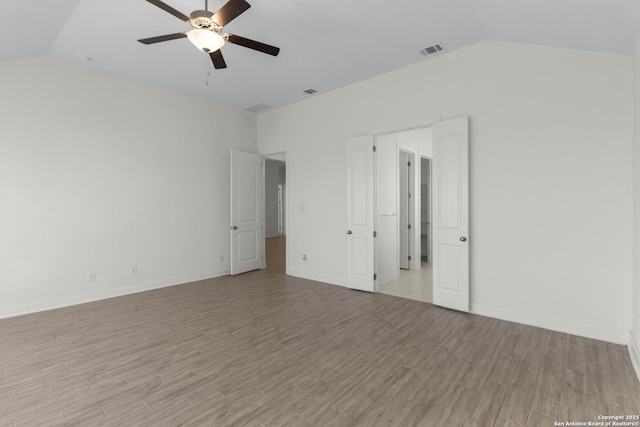 unfurnished room with ceiling fan, lofted ceiling, and light hardwood / wood-style flooring