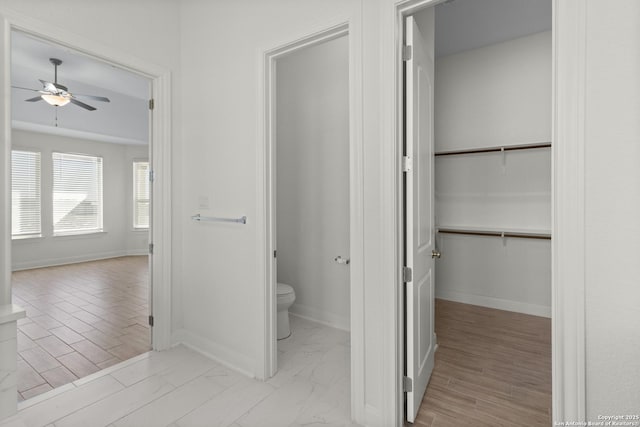 bathroom with hardwood / wood-style flooring, ceiling fan, and toilet