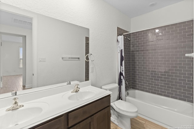 full bathroom featuring wood-type flooring, toilet, vanity, and shower / bath combo with shower curtain