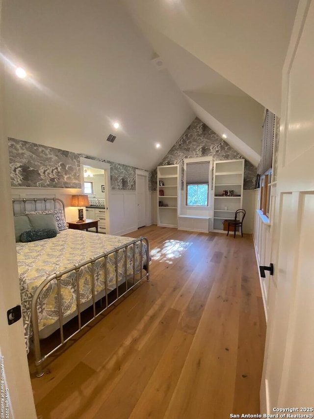 bedroom featuring lofted ceiling, visible vents, and light wood-style floors