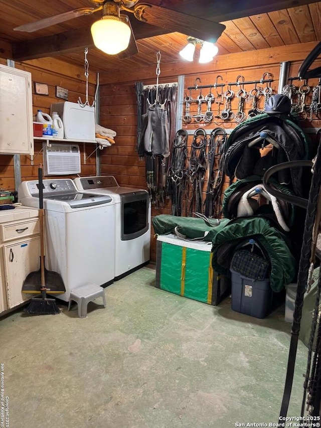 laundry room with wood ceiling, independent washer and dryer, and wood walls