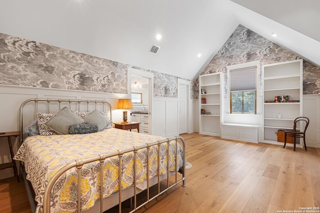 31545 Meadow Crk, Fair Oaks Ranch, TX 78015 - bedroom with visible vents, wainscoting, lofted ceiling, light wood-style floors, and wallpapered walls