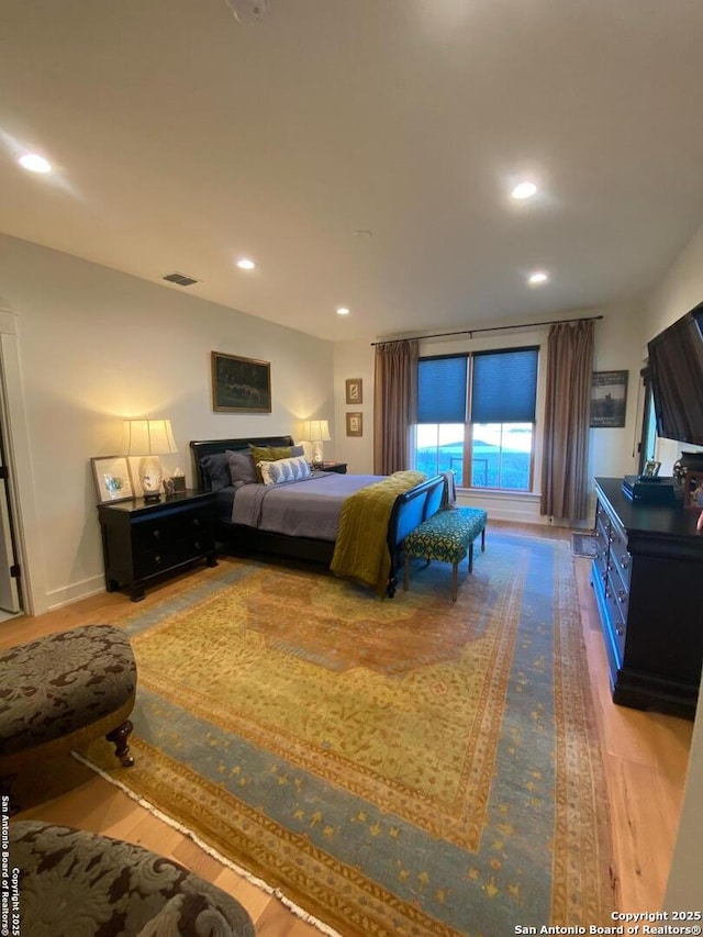 bedroom with wood finished floors, visible vents, and recessed lighting