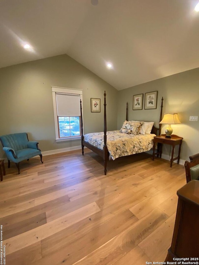 bedroom featuring light wood-style floors, vaulted ceiling, and baseboards