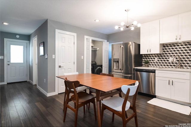 dining space with washer / dryer, sink, a chandelier, and dark hardwood / wood-style flooring