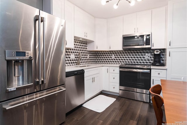 kitchen featuring sink, appliances with stainless steel finishes, tasteful backsplash, white cabinets, and dark hardwood / wood-style flooring