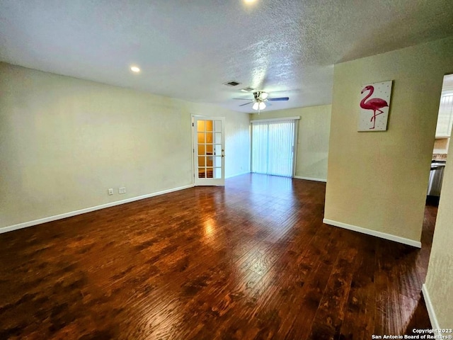 empty room with ceiling fan, a textured ceiling, and dark hardwood / wood-style flooring