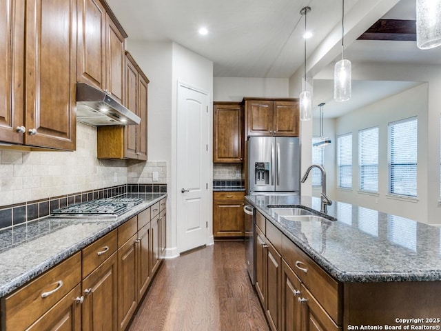 kitchen with dark wood-type flooring, sink, hanging light fixtures, an island with sink, and stainless steel appliances