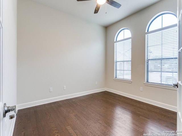 spare room featuring dark wood-type flooring and ceiling fan