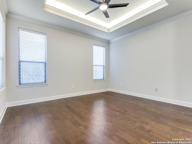 spare room with dark hardwood / wood-style floors, ornamental molding, a raised ceiling, and ceiling fan