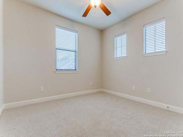 carpeted empty room featuring ceiling fan and a healthy amount of sunlight