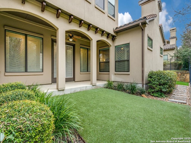 doorway to property with a yard and ceiling fan