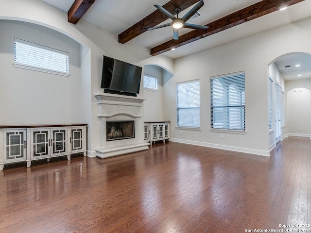 living room featuring beamed ceiling, dark hardwood / wood-style floors, and ceiling fan